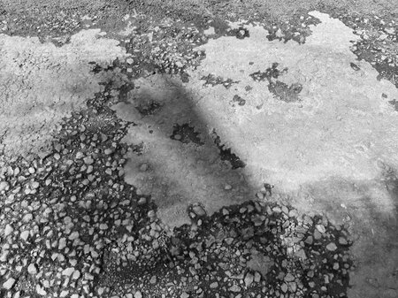 Gravel and asphalt with shadow on a sunny dayの写真素材