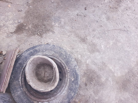 an unused car wheel, cement bucket, and ceramic tile on cement floor during constructionの写真素材