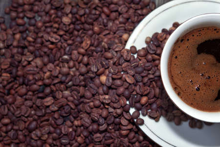 coffee cup and coffee beans on wooden table
