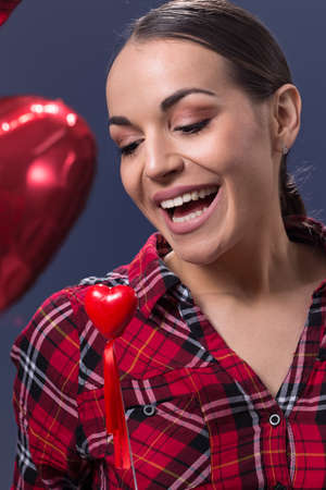 Red heart symbol of Valentines day smiling woman hold