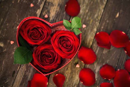 background with red roses over wooden table. Top viewの写真素材