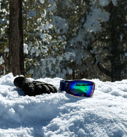 ski glasses and gloves on snow at wonderful sunny day backgroundの写真素材