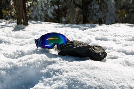 Colorful ski glasses and gloves on snow at wonderful sunny dayの写真素材
