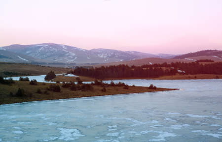 Frozen river, winter landscape in soft pink sunset lightの写真素材