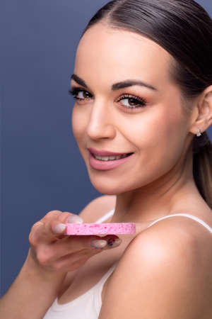 Young woman using a cotton pad to remove her make-up .Smiling young girl cleaning her face with cotton disc. Beauty skin careの写真素材
