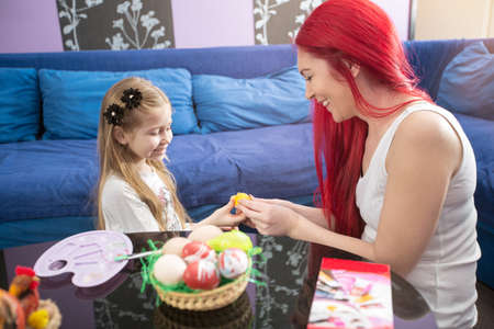 Mother and young daughter paint Easter eggs. celebrate Easterの写真素材