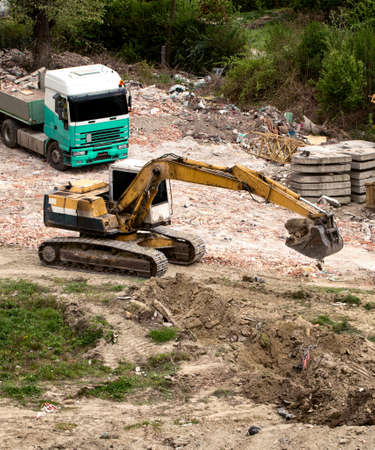 yellow crawler excavator machine on the construction site dig holeの写真素材