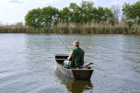 river fishing- man catching fish in boatの写真素材