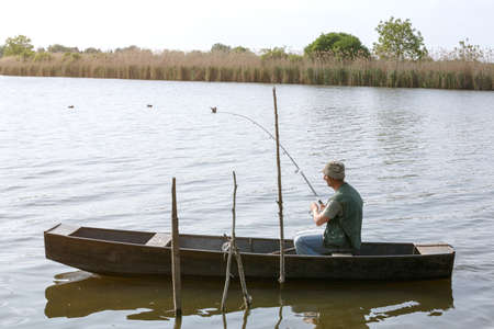 Fisherman catching fish in river