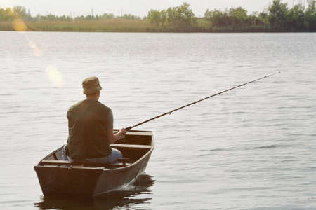 fisherman fishing-man catching fish in boatの写真素材