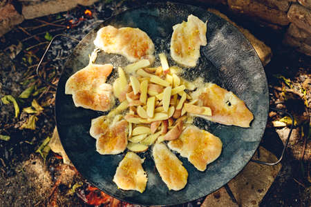 top view of juicy chicken meat and potato being grilled in a barbecue