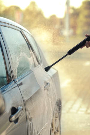 Close up of cleaning Car Using High Pressure Water. Man washing his car under high pressure water in serviceの写真素材