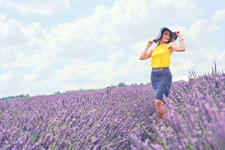 young beautiful girl is in the lavender field, beautiful summer landscape with flowersの写真素材