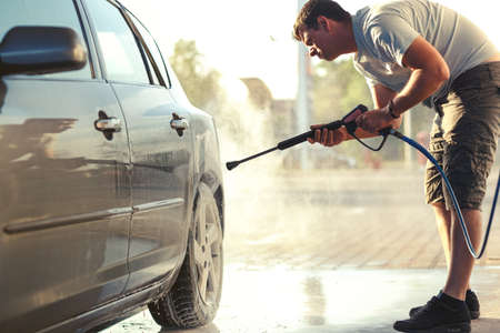Man washing car wheel. Car cleaning with water jet. Car rim wash close up close upの写真素材