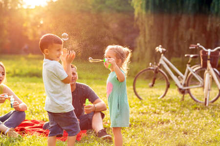 family time- Happy cute children chase bubbles in natureの写真素材