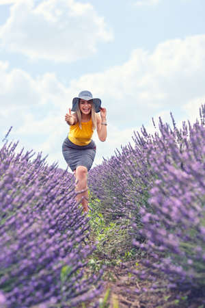 young beautiful girl is in the lavender field, beautiful summer landscape with flowersの写真素材