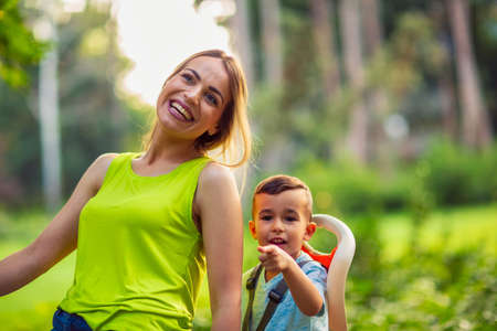Happy family.Boy on bike with smiling mother - lovely family having quality time outdoorsの写真素材