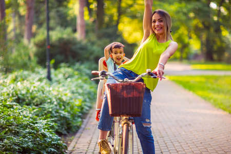 Happy family Family sport and healthy lifestyle- Boy on bike with smiling mother - lovely family having quality time outdoorsの写真素材