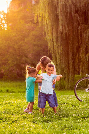 Happy young mother play with his son in nature.の写真素材
