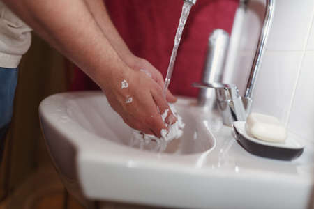 Morning hygiene, Guy wash his hands after shaving close up