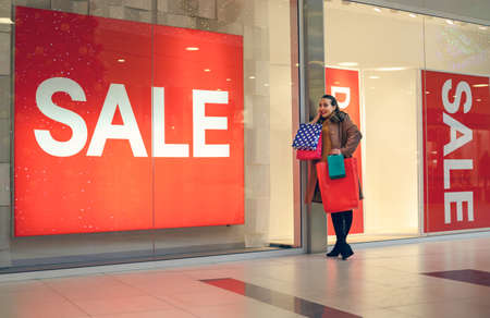 shopping and promotion concept- smiling woman with shopping bagsの写真素材