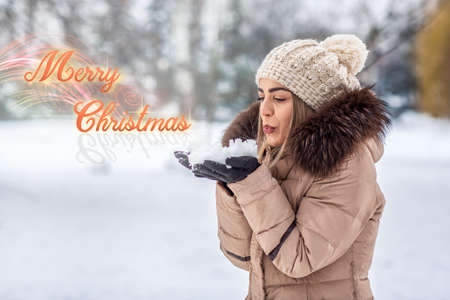 beautiful young girl blowing magic snow Marry Christmasの写真素材