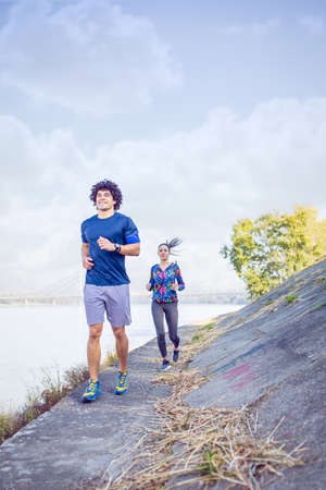 sporty couple running and jogging outdoors.