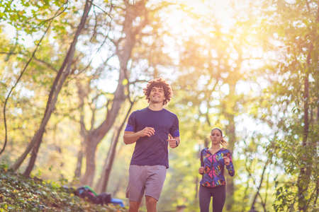 running is fun- Young Couple jogging and running outdoors in nature
