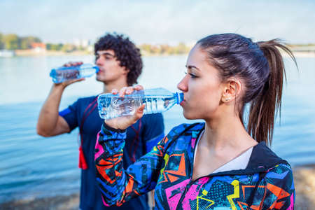 Resting After Workout- Woman drinks water to replenish energyの写真素材
