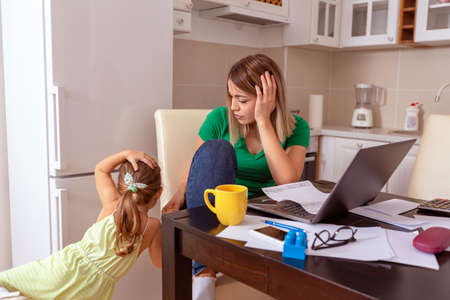 Family budget and finances- young female with daughter planning home budget