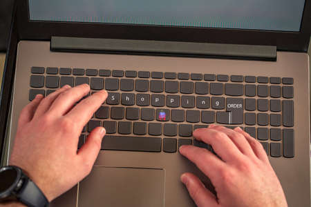 Online shopping-male hands typing on laptop keyboard close upの写真素材