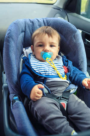Boy sitting in a car in safety chair. Protection in the car.