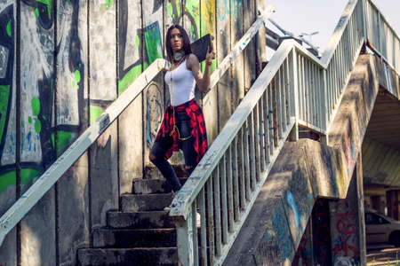Cute teen girl with skateboard. Outdoors, urban lifestyle