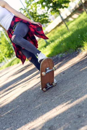 Girl skateboarder -  legs skateboarding in parkの写真素材