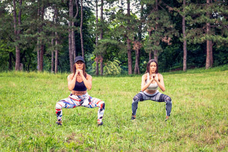 Cross training. Young women exercising at the nature togetherの写真素材