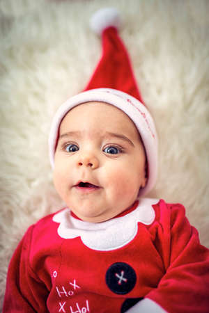 Smiling  Baby boy  in santa claus costume on Christmas day.