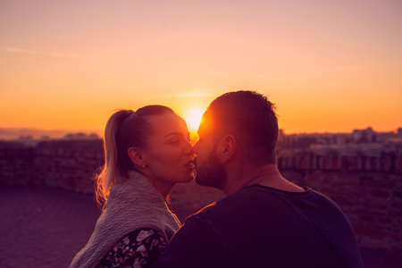 Young couple in love kissing at evening  in sunset の写真素材