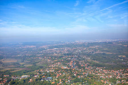 beautiful panorama of city downtown houses and church aerial view above the roofs with sun in summerの写真素材