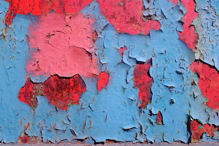 Old peeling paint. Solid background with blue and red paint craquelure colorの写真素材