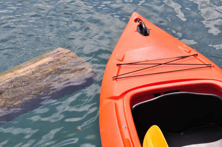 Head of orange kayak floating on lakeの写真素材