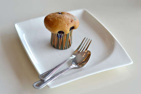 Muffin on a plate with a spoon and forkの写真素材