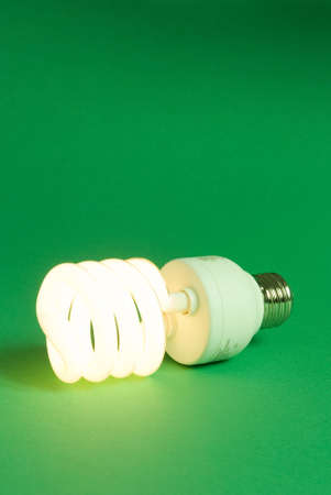 a compact fluorescent lightbulb on a green backgroundの写真素材