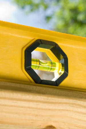 a yellow plastic builders level sits on top of a railingの写真素材