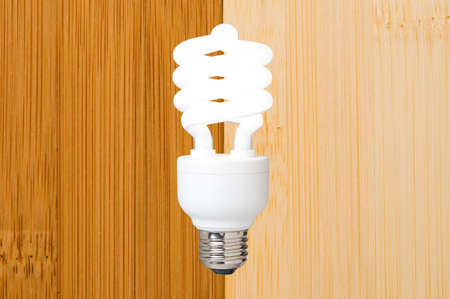 a compact fluorescent light bulb against a bamboo flooring backgroundの写真素材