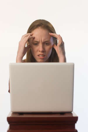 An angry confused young woman looking at her laptop screenの写真素材