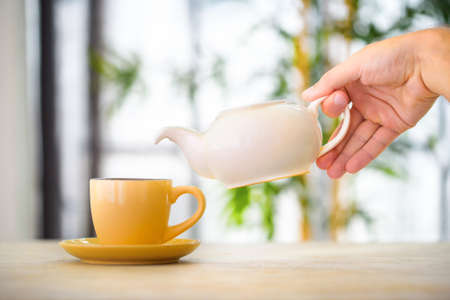 Side view of a male pouring teaの写真素材