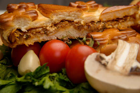Puff pastry meat pie with vegetables on rustic backgroundの写真素材