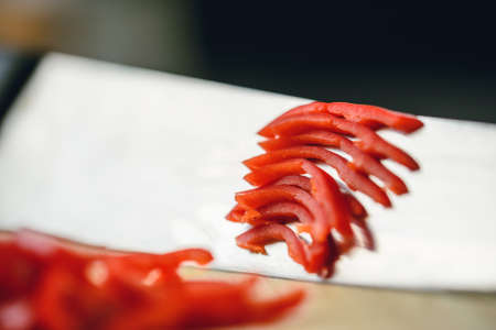 Cutting chili pepper with knife on wooden surfaceの写真素材