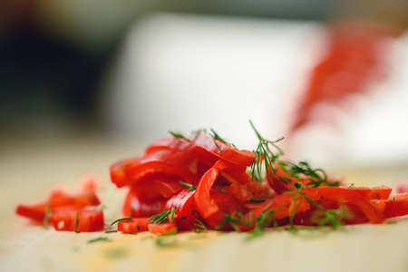 Cutting chili pepper with knife on wooden surfaceの写真素材