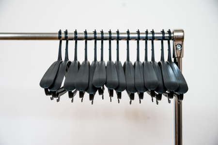 Many unoccupied black hangers at a clothing storeの写真素材